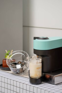 Kahve fincanı ve kahve makinesi masanın üstünde.