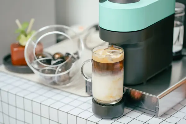 Kahve fincanı ve kahve makinesi masanın üstünde.