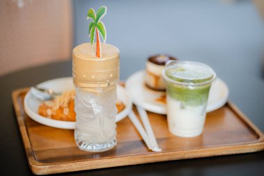 Bir bardak buzlu kibrit yeşil çay yaz terasında bir kahvecinin ahşap masasında buzlu kahve, menü fotoğrafçılığı..