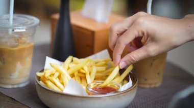 Patates kızartmasını kafede kırmızı sosa batıran kadını kapatın..