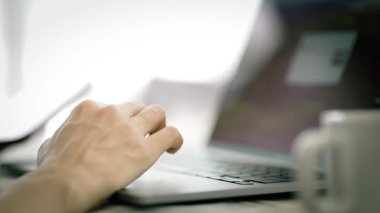 Evdeki oturma odasında akıllı telefon ve dizüstü bilgisayar kullanan kadınların yakın görüntüsü.