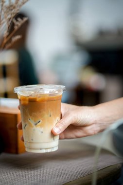 Elinde bir fincan buzlu kahve tutan kadın. 