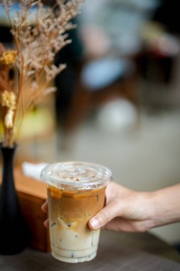 Elinde bir fincan buzlu kahve tutan kadın. 