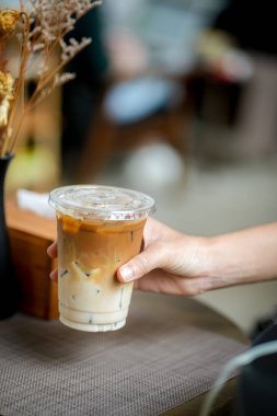 Elinde bir fincan buzlu kahve tutan kadın. 