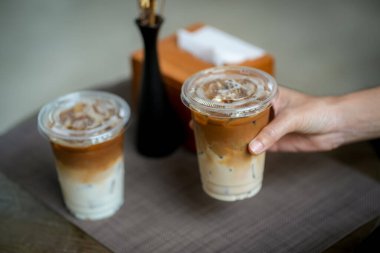 Elinde bir fincan buzlu kahve tutan kadın. 