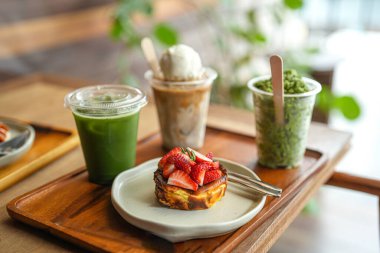 Masada nefis kahvaltı, çilekli pasta ve farklı içecekler. 