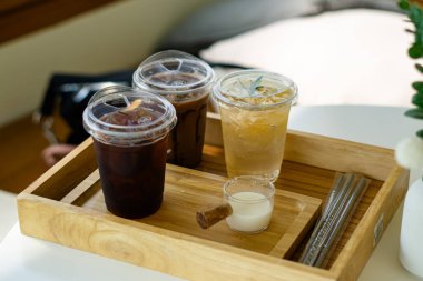 Tahtadaki plastik bardaklarda farklı içecekler.  