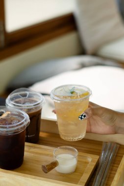 Tahtadaki plastik bardaklarda farklı içecekler.  