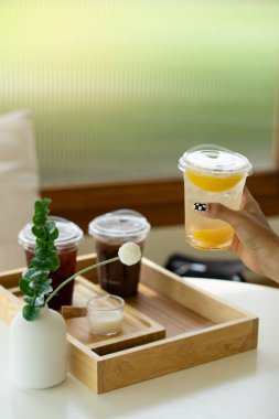 Tahtadaki plastik bardaklarda farklı içecekler.  