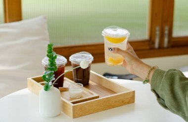 Tahtadaki plastik bardaklarda farklı içecekler.  