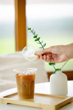 Kahve fincanına süt döken el.  