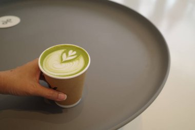 Matcha latte 'yi elinle kapat. 