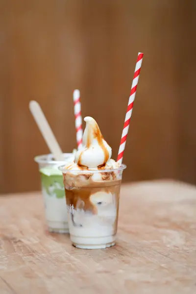 Bir bardak kremalı dondurma ve arka planda kibrit.