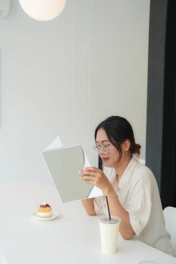 Asyalı kadın evde çalışırken tablet bilgisayar kullanıyor