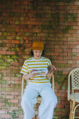 Duvarda şarjörü olan genç ve güzel bir kadın. 