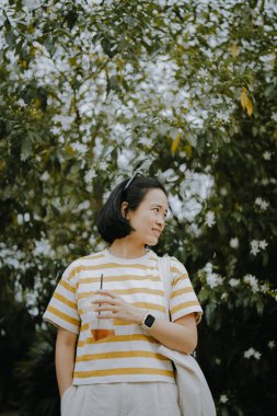 Parkta yürüyen Asyalı kadın. 