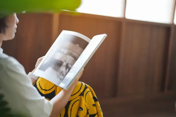 Kafede kitap okuyan güzel Asyalı bir kadın. 