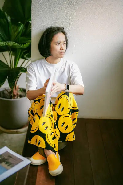 Kafede kitap okuyan güzel Asyalı bir kadın. 