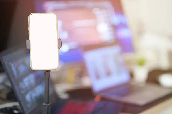 Boş beyaz cep telefonu ekranına odaklan, maket yap. Model tasarım şablonu için boş izole görüntüsü olan akıllı telefon ön masadaki tripodun üzerinde duruyor, bulanık arkaplan