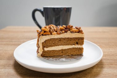 Karamelli bademli şekerleme. Tahta bir masada, ayrı bir konteynırda, kahverengi iğne kahveli kek.