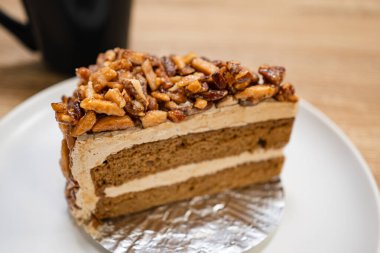 Karamelli bademli şekerleme. Tahta bir masada, ayrı bir konteynırda, kahverengi iğne kahveli kek.