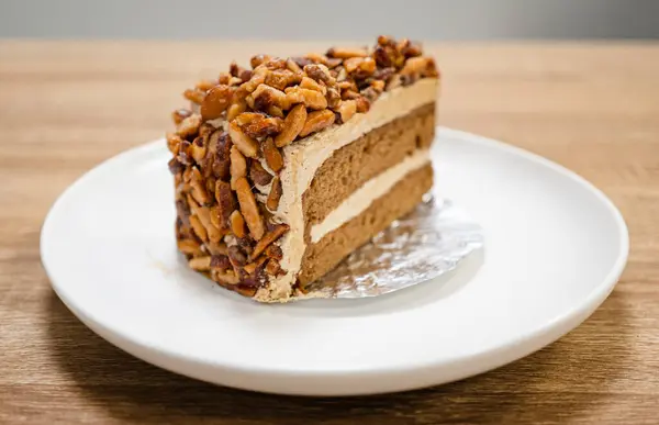 Karamelli bademli şekerleme. Tahta bir masada, ayrı bir konteynırda, kahverengi iğne kahveli kek.