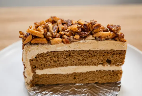 Karamelli bademli şekerleme. Tahta bir masada, ayrı bir konteynırda, kahverengi iğne kahveli kek.