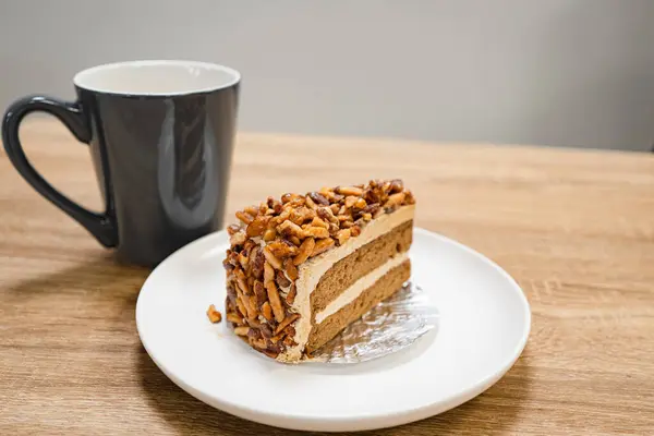 Karamelli bademli şekerleme. Tahta bir masada, ayrı bir konteynırda, kahverengi iğne kahveli kek.