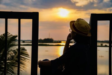 Gün batımının doğa manzarası, rıhtımda duran kadın.