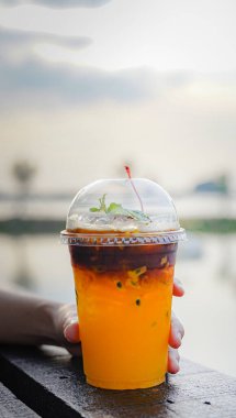 Plastik bardakta buzlu kahve tutan el. 