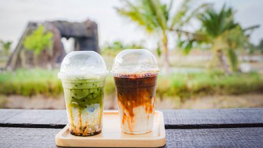 Yakın çekim ve seçici odaklı buzlu kibrit latte ve ahşap masada buzlu kahve sütü..