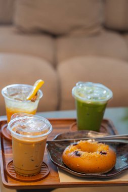 Espresso tonik, buzlu latte ve buzlu kibrit gibi içkilerle dolu bir sehpa.