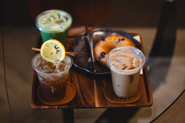 Espresso tonik, buzlu latte ve buzlu kibrit gibi içkilerle dolu bir sehpa.