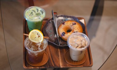 Espresso tonik, buzlu latte ve buzlu kibrit gibi içkilerle dolu bir sehpa.