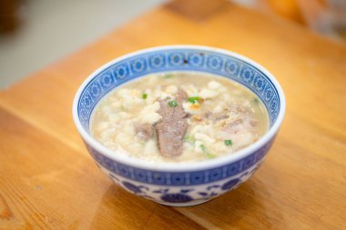 Bir kase pirinç lapası ve et dilimleri.