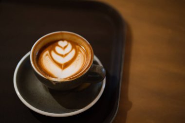 Masadaki gri bardakta Latte sanatı