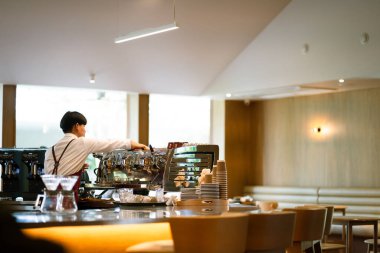 BANGKOK, THAILAND - 29 Mayıs 2025: Barista modern kafenin içinde kahve yapıyor.