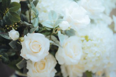 Narin bir buket beyaz çiçek ve yeşil yapraklar..