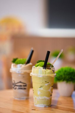 Ahşap bir masada taze nane şekeriyle karıştırılmış iki içecek..