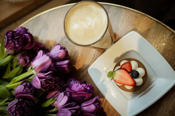 Sıcak kapuçino, kek ve kafedeki masada laleler. Yüksek kalite fotoğraf