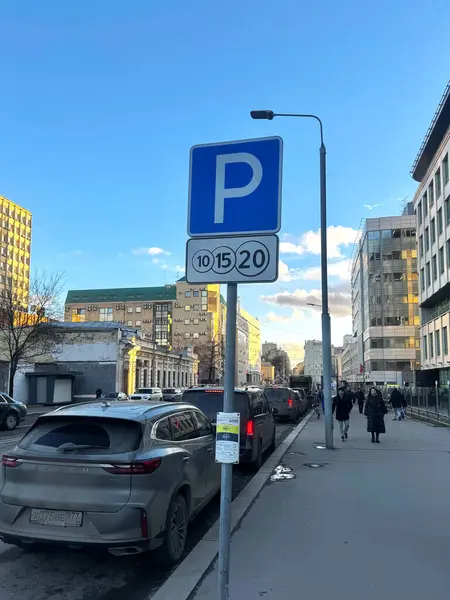 Şehir merkezindeki otoparklarda, park tabelasında. Yol kenarına park edilmiş sıra sıra arabalar. Yüksek kalite fotoğraf