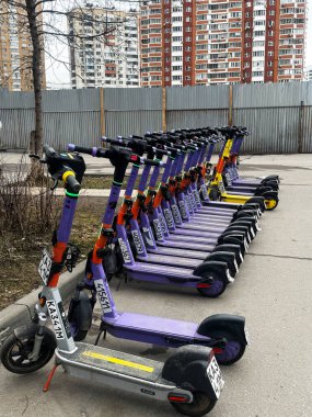 MOSCOW, Rusya, 05.03.2025. Şehrin caddesindeki elektrikli scooter kiralama istasyonu. Özel bir akıllı telefon uygulaması ile kiralanmış. Yüksek kalite fotoğraf