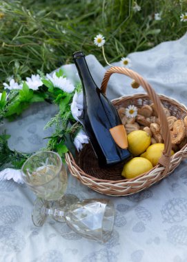 Kurabiye, meyve, şarap ve bardakla papatya tarlasında yaz pikniği. Arka planda papatya çiçekleri var. Yüksek kalite fotoğraf