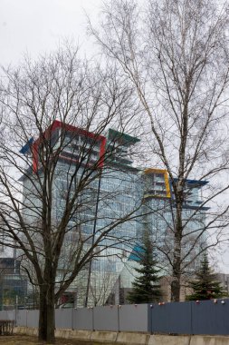 Kuntsevo Plaza Alışveriş Merkezi, uzaktan, ağaçların arasından, ön planda işaret lambaları olan bir çit. Moskova. Rusya 3 Mart 2025. Yüksek kalite fotoğraf