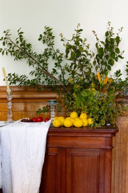 Ağaç dallarıyla süslenmiş bir sandık dolusu çekmece, üzerinde domatesli, zeytinli ve limonlu bir tabak yiyecek yatıyor. Yüksek kalite fotoğraf