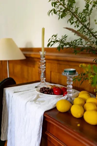 Ağaç dallarıyla süslenmiş bir sandık dolusu çekmece, üzerinde domatesli, zeytinli ve limonlu bir tabak yiyecek yatıyor. Yüksek kalite fotoğraf