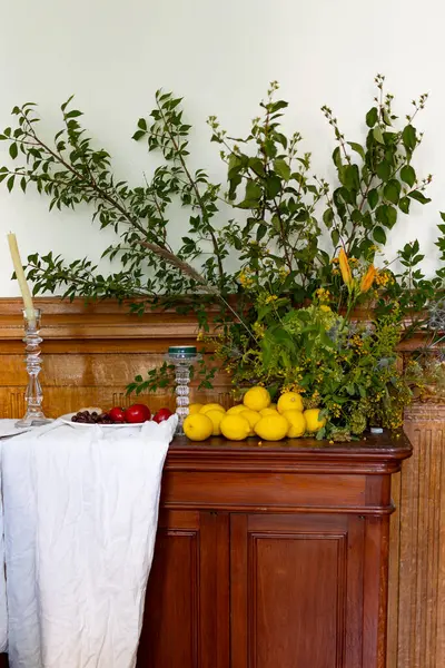 Ağaç dallarıyla süslenmiş bir sandık dolusu çekmece, üzerinde domatesli, zeytinli ve limonlu bir tabak yiyecek yatıyor. Yüksek kalite fotoğraf