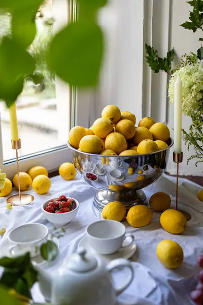 Yeşil yapraklı, zeytinli, beyaz masa örtüsünde üzümlü taze limonlar. Yüksek kalite fotoğraf