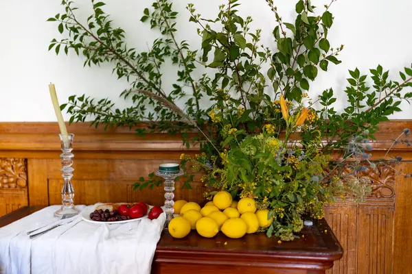 Ağaç dallarıyla süslenmiş bir sandık dolusu çekmece, üzerinde domatesli, zeytinli ve limonlu bir tabak yiyecek yatıyor. Yüksek kalite fotoğraf
