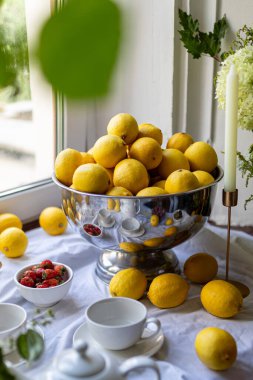 Yeşil yapraklı, zeytinli, beyaz masa örtüsünde üzümlü taze limonlar. Yüksek kalite fotoğraf